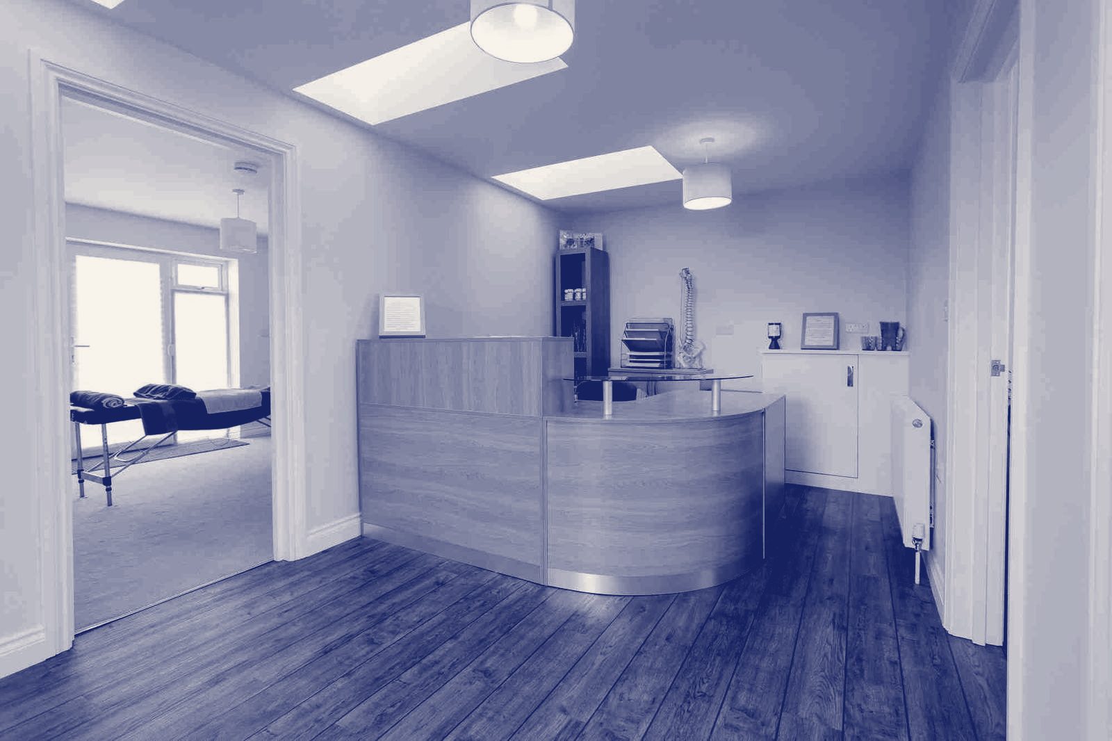 The bright reception area with a curved wooden desk
